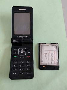 三星W579手机配件机，电池鼓包开裂，夹电测试不开机，屏有划