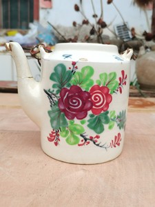 建国前后的老茶壶，一面手工花卉图案，另一面茶味清香，壶肩上书