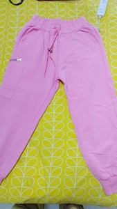 出粉色的女性卫裤，款式为束脚裤，颜色为粉色，长度为长裤。这条