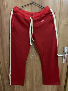 女暗红色运动长裤拉链系带条纹，左右各有两个兜，兜有拉链，拉链