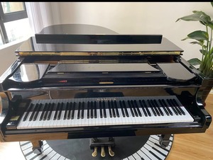 出一架黑色的Samick钢琴，颜色为亮光黑，款式为三角钢琴，