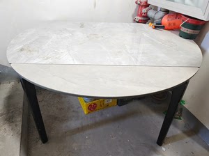 岩板长方形餐桌，可拉成圆桌，桌角有小面积破损，铺上桌布完全不