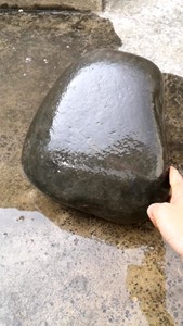 一块黑灰色压菜石，密度高。一面平整。也适合做雕刻绘画，碑文等