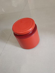出红色塑料罐，适用于食品、茶叶等物品的储存。罐子带有盖子，密