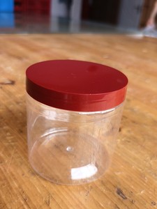 出透明色的塑料罐子，带有红色的盖子，款式简单大方。适用于储存