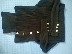 24出黑色百搭高领毛衣，袖口和肩膀等处有扣子作为点缀。