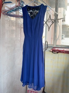 宝蓝色连衣裙，后背黑色缕空蕾丝稍显性感，下摆不规则设计