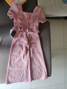 出一套粉色的格子两件套，包括短袖上衣和阔腿裤。材质为棉质，风
