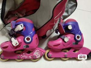 出一双闲置的儿童轮滑鞋，品牌为OXELO，颜色为粉色和紫色，