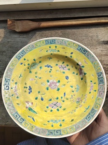 春节收拾出一个珐琅彩瓷盘。直径23cm，底足磨款。黄地彩瓷彩