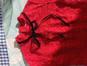 朵以红色蕾丝连衣裙，里面有内衬，领口那有黑色蝴蝶结，适合春秋