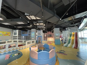 出款色彩鲜艳的儿童室内游乐场，包括多种玩乐设备，如滑梯、爬坡