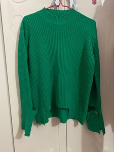 草绿色针织毛衣，不规则宽松版，前短后长，袖口有开口，扣子设计
