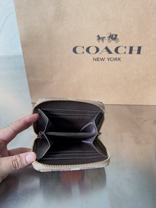 出蔻驰女款棕色短款钱包，采用经典COACH品牌设计风格，钱包