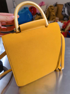 颜色特别正的姜黄色麂皮包包一个，木质手柄，很漂亮，可手提斜挎