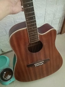 出一把闲置的棕色民谣吉他，品牌海伦1893。正品可查有防伪编