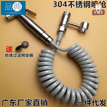 With spray gun connected to the faucet flush toilet hand nozzle cleaning the flush hose next to the stainless steel tap of the spray gun