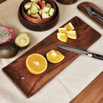 A plank or otherwise] black walnut wood breadboard fruit board chopping board