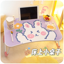  A small table on the bed folds the girls bedroom and sits on the floor The girl puts a small table in the dormitory to write on the net red learning desk
